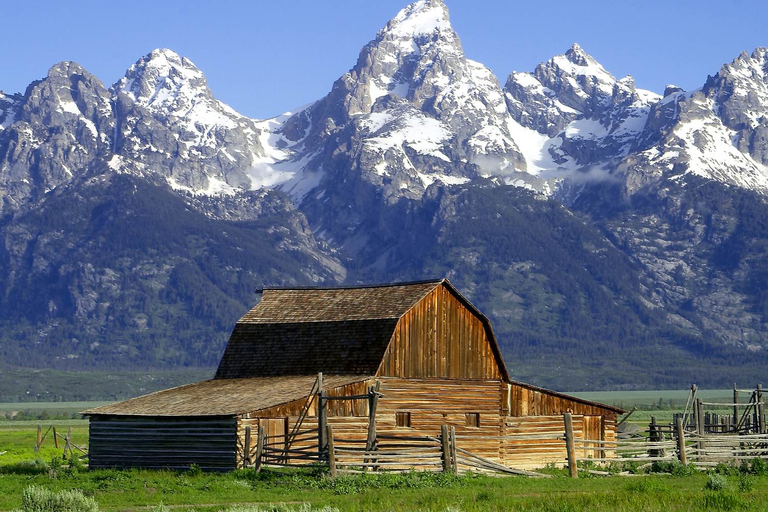 Two old barns on Mormon Row with the Teton Range behind them.